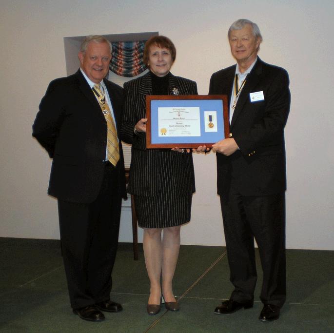 President Tom Speelman presents the Teacher of the Year award to Mary Lou Wentzel. Larry McKinley also pictured (left).