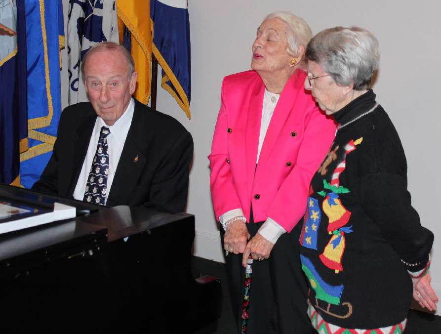 Bob Rosenbaum favors the crowd with a tune as Vinson Hall residents, including Jane Peak (right), look on