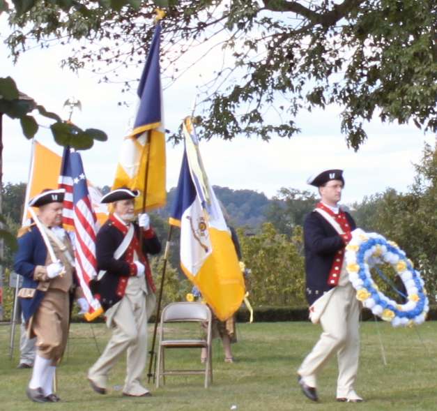 An Honor Guard comprised of Larry McKinley (left) and Andrew Johnson (right) accompany Compatriot Darrin Schmidt with the Fairfax Resolves wreath