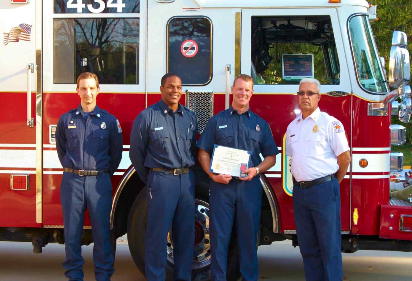 Dan Hahn displays his Fire Safety Commendation Medal and certificate with members of Fire Station 34