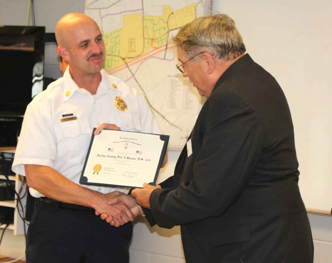 Deputy Chief James Walsh, Opns. A-Shift, receives a flag certificate from Chapter President Jack Sweeney on behalf of Fairfax County Fire Station No. 422.