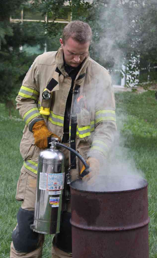 Firefighter Hall douses the fire after the flags have been properly retired.