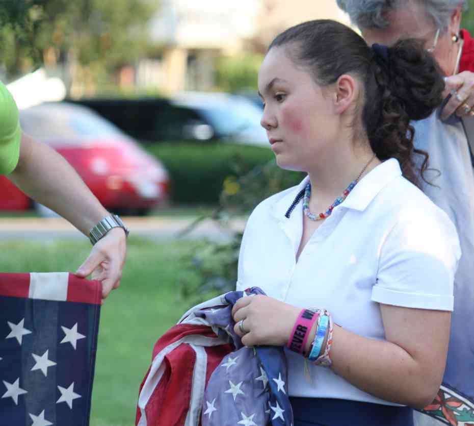 A member of the C.A.R. prepares the next flag for retirement.