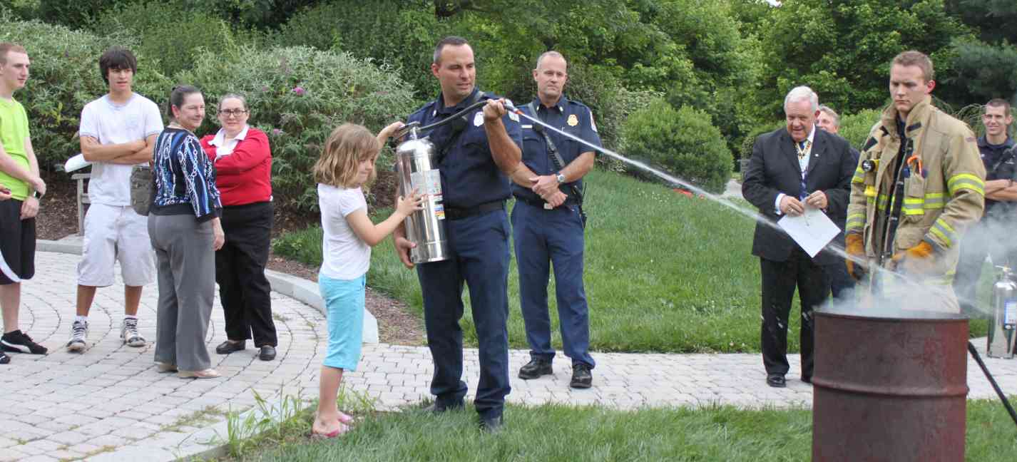 Adults look on with envy as the young C.A.R. member gets to try out the fire departments fire extinguisher.