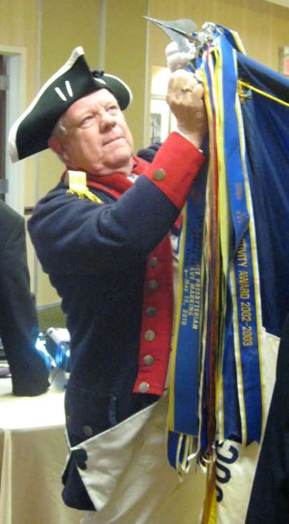 Guardsman Larry McKinley adds new streamers to the VASSAR flag.