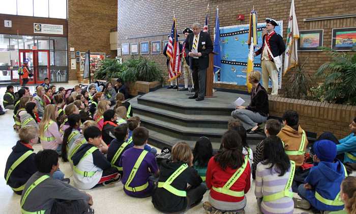 President Jack Sweeney talks about how the SAR seeks to recognize community members such as the Oak Hill students for their patriotic contributions to the community as members of the Safety Patrol listen.