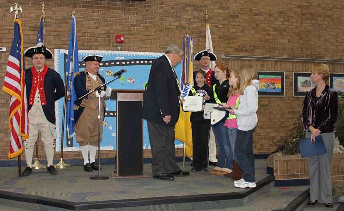 President Jack Sweeney presenting the Oak Hill Safety Patrol Captains with Flag Certificates and pins for their daily rendering of the Colors at the school. Principal Amy Goodloe was also recognized. The Color Guard participants included Dan Rolph, Larry McKinley (in the Washington's staff uniform) and Darrin Schmidt.