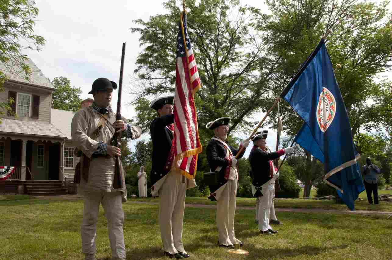 Chapter President Darrin Schmidt (US Flag) leads Andy Johnson (middle) and Larry McKinley while members of the First Viginia Regiment form the guard (far right and left).