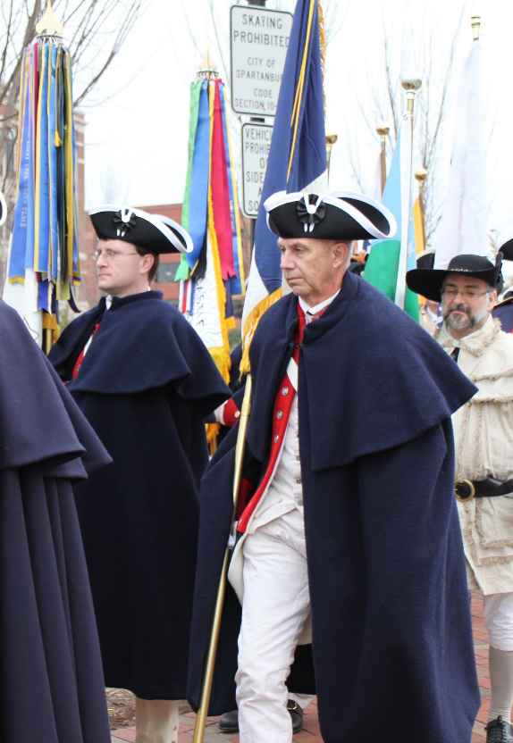 Darrin Schmidt (left) and Peter Davenport marching in carrying their respective Chapter flags: Fairfax Resolves and George Mason.