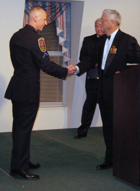 Fairfax County Police Detective receiving the Law Enforcement Commendation Medal from Compatriot Vernon Eubanks.