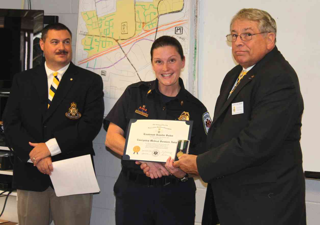 Lt. Svites receives her award from President Jack Sweeney (left) as Chairman Andrew Monahan looks on.