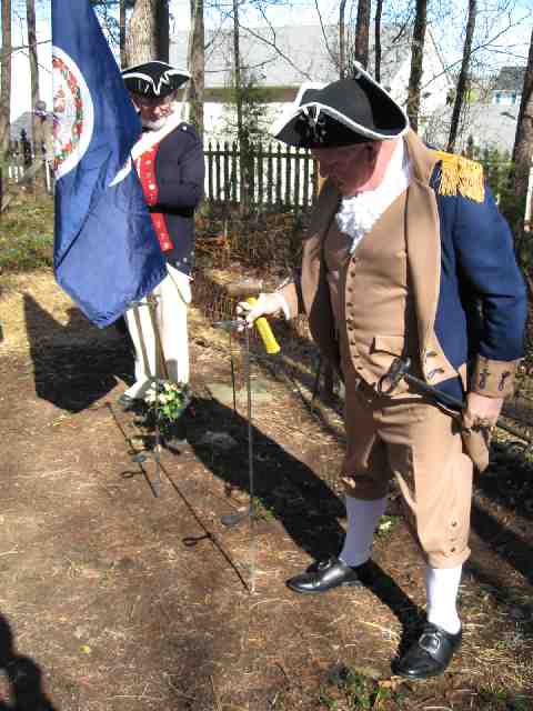 Guardsman Andy Johnson watches and Color Guard Commander Larry McKinley prepares for the ceremony by setting stakes for the flags.