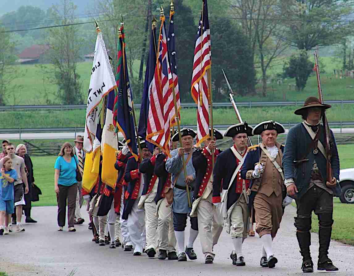 The combined Colorguard leads the crowd to the monument